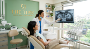 A professional dentist explaining dental care services to a patient at The Tusk Dental Clinic in Kasba.
